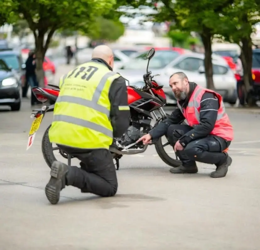 Two instructors checking a motorcycle before training