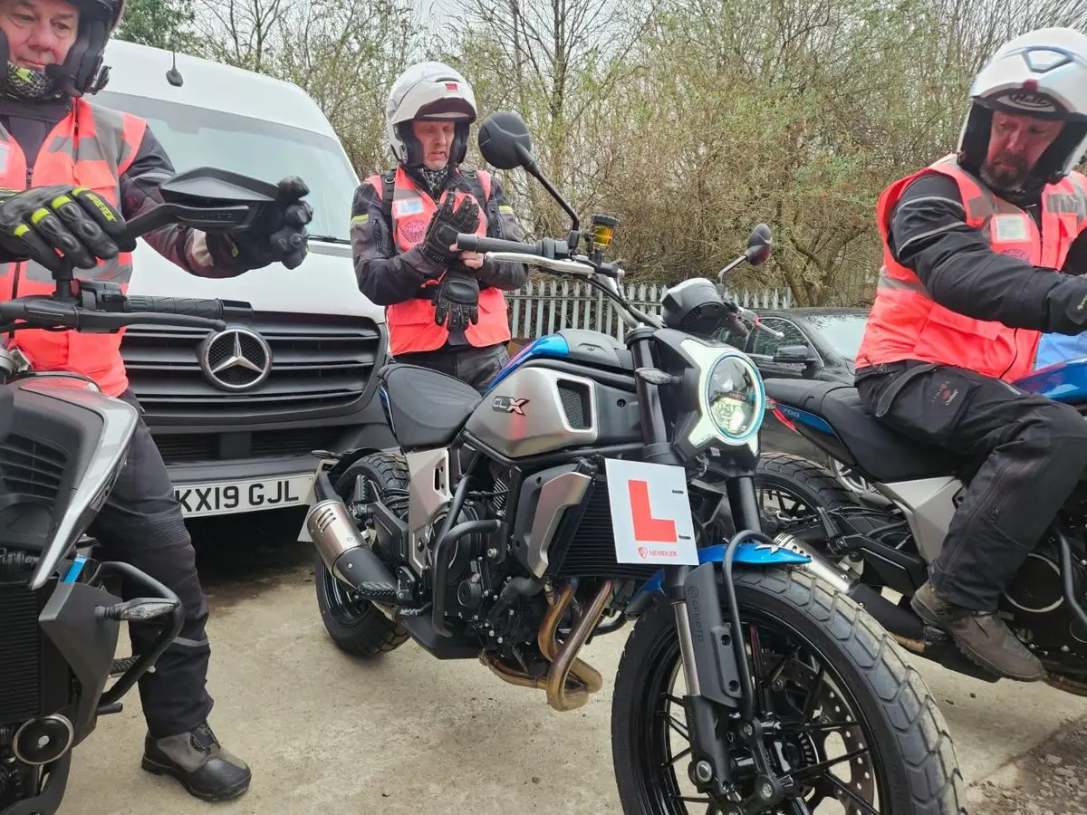 Riders on training motorcycles with L-plates at the yard